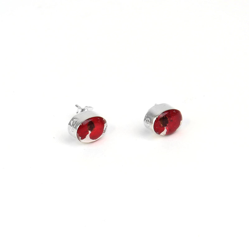 Oval poppy stud earrings lying on side