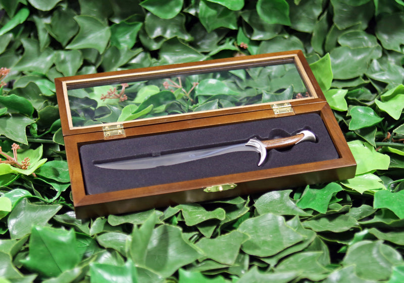 Orcrist replica letter opener in open wooden display case on a bed of ivy