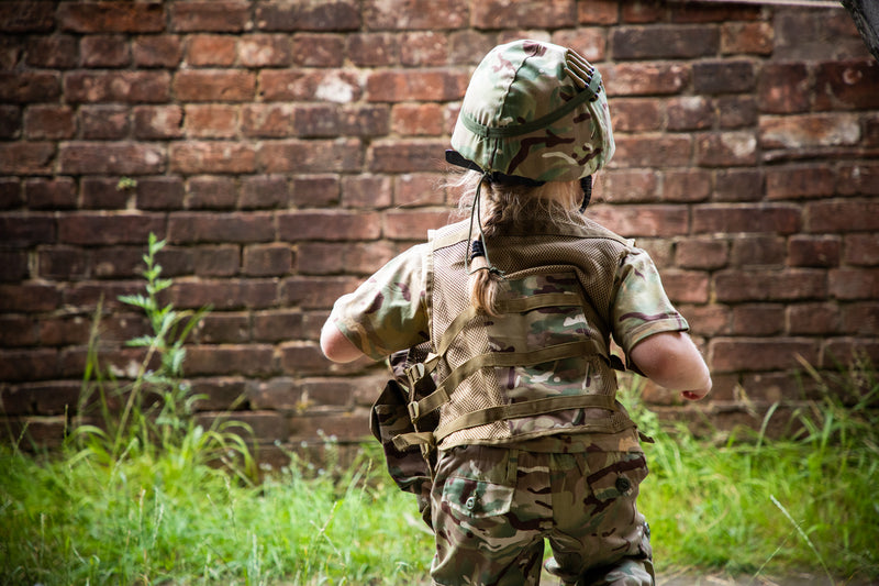 child wearing Children’s camo assault vest in multi terrain DPM near brick wall