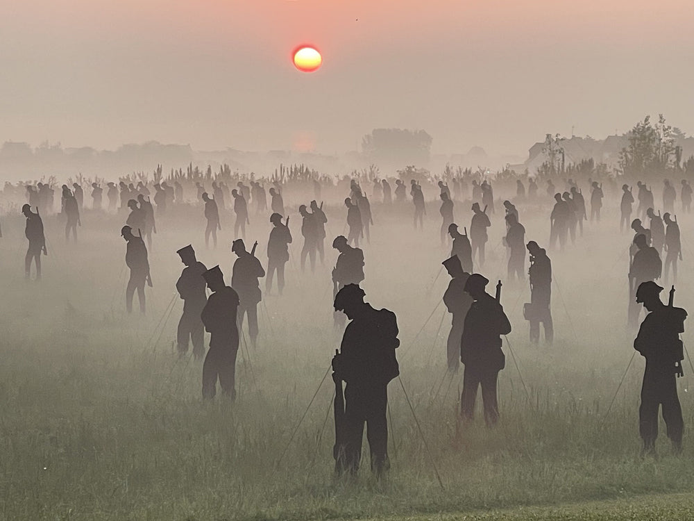 Silhouettes of people in a field with a sunset in the background. Photo credit Amanda Walden