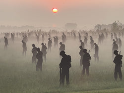 Silhouettes of people in a field with a sunset in the background. Photo credit Amanda Walden