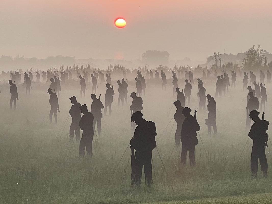 Silhouettes of people in a field with a sunset in the background. Photo credit Amanda Walden