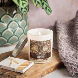 Fresh Linen Scented Candle - Archers Sleeve displayed with matches and a blanket with reed defuser in the background