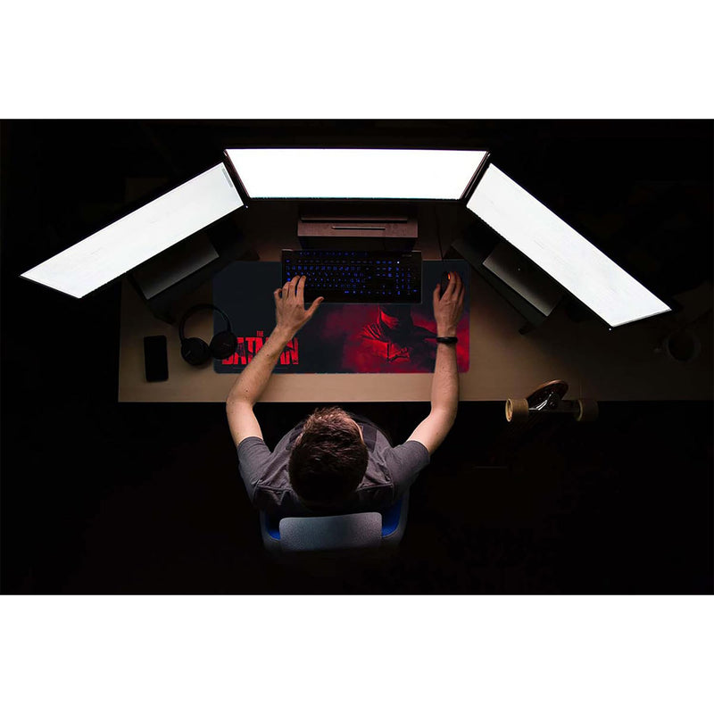 Person sitting at a desk with a computer setup in a dark room