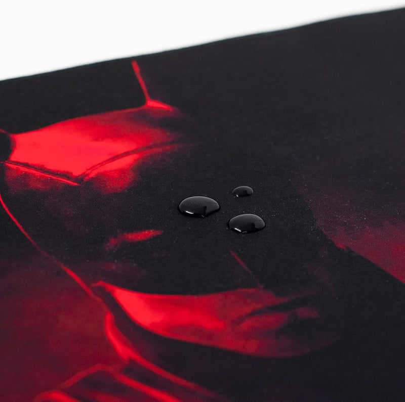 Close-up of a black surface with red lighting and water droplets.