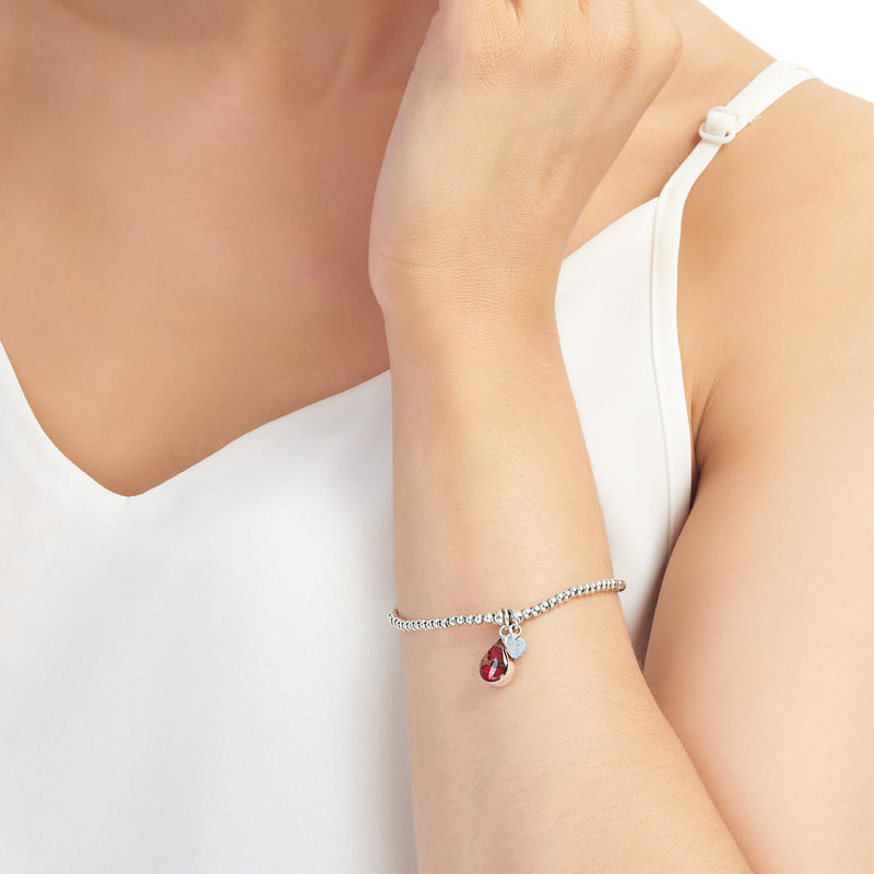 Beaded poppy bracelet with love heart charm on model