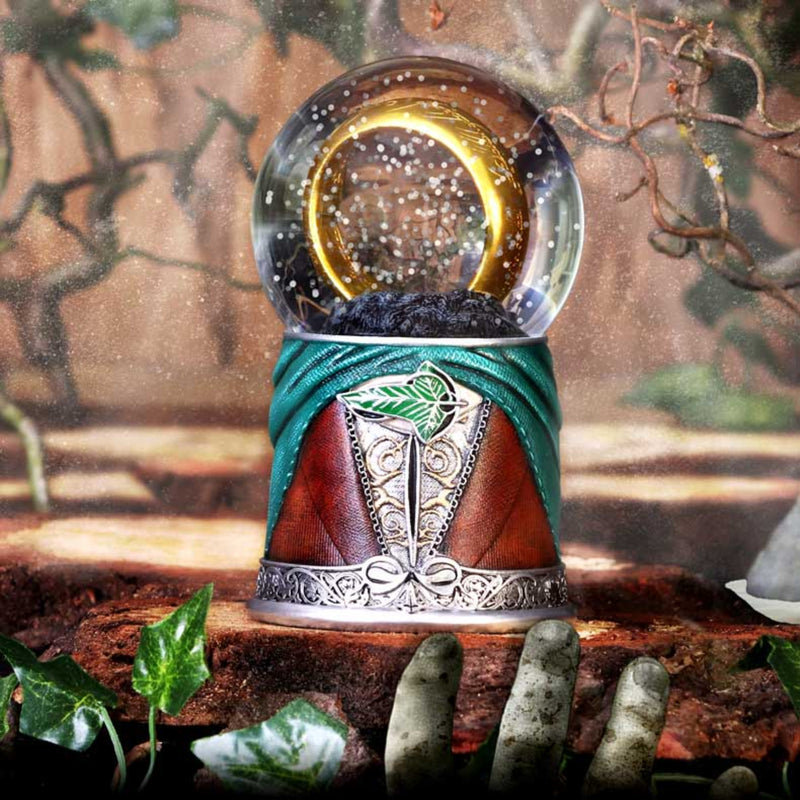 Decorative snow globe with a fantasy design on a wooden surface with leaves.