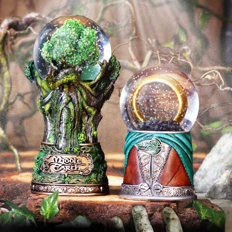 Two decorative snow globes with fantasy designs on a wooden surface.