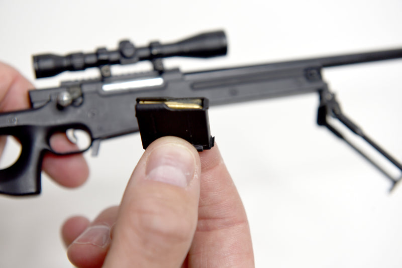 Close up of the model L96A1's magazine with the ammo visible inside. A hand can be seen holding the rest of the model in the background