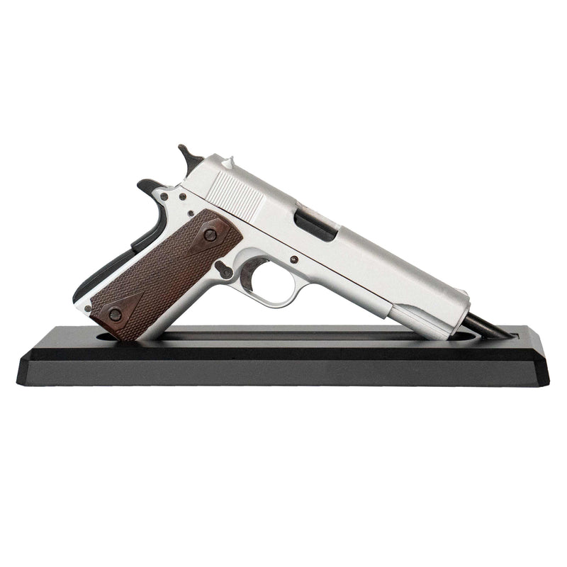 Silver model 1911 mounted on its display stand pointing to the right.