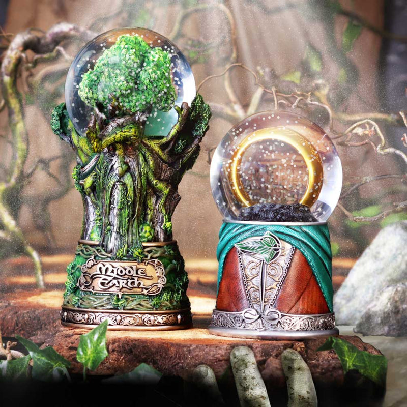 Two decorative snow globes with natural themes on a wooden surface.