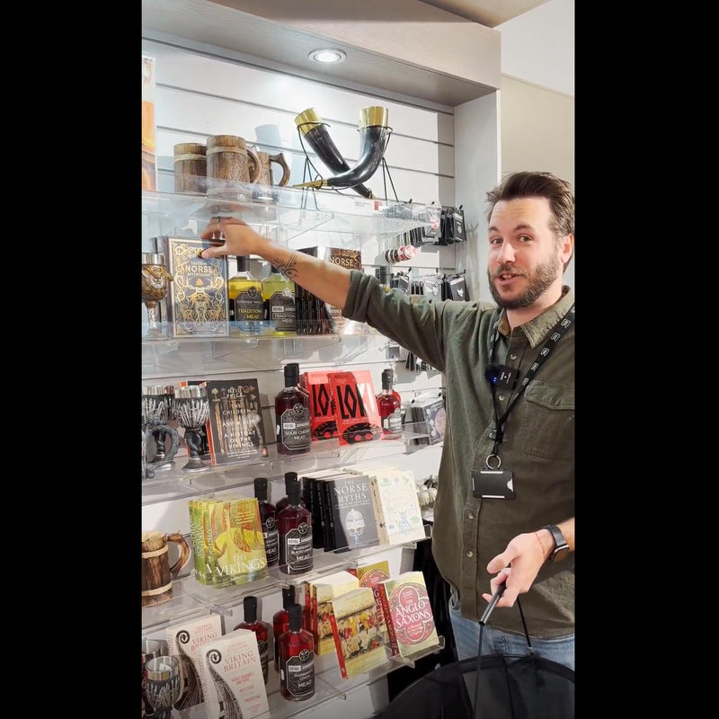 Royal Armouries Assistant Curator of Arms and Armour, Scott Hurst, taking the Tales of Norse Mythology book off the shelf in the Royal Armouries  museum shop