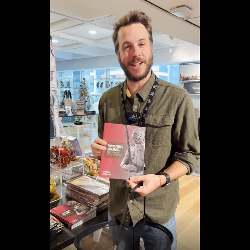 Royal Armouries Assistant Curator of Arms and Armour, Scott Hurst, holding the Tudor Power and Glory book in the museum shop 