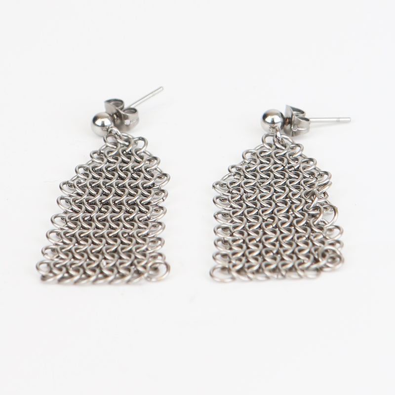 Close up of silver stud earrings with dangling chainmail details
