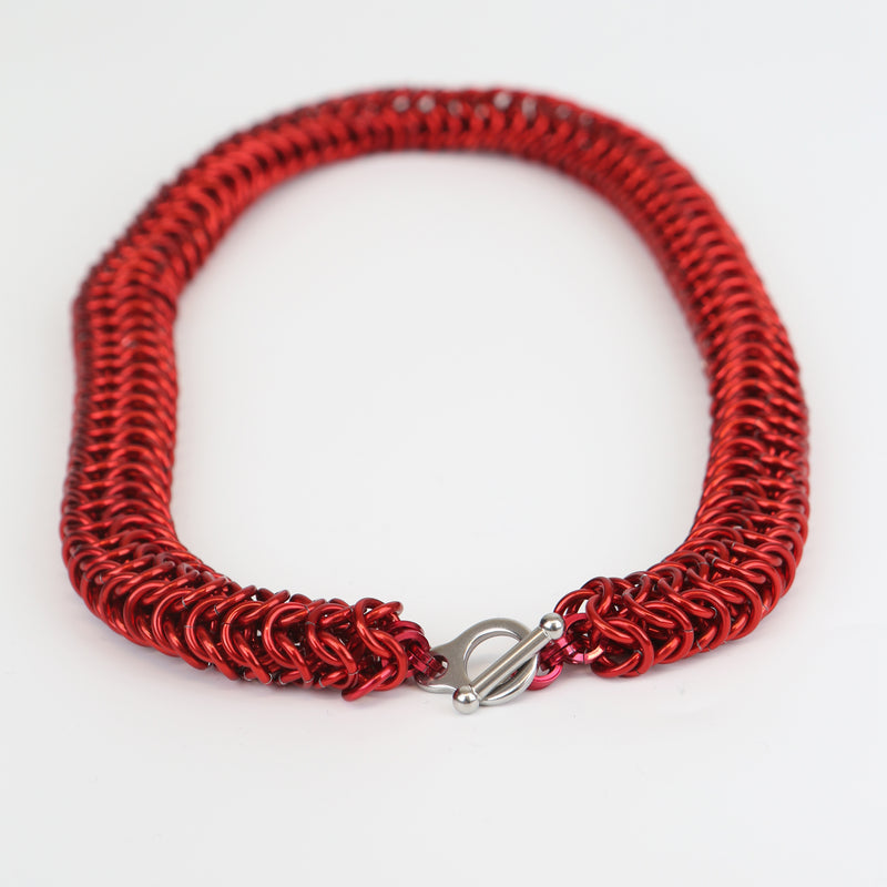 Intricately linked chunky chainmail necklace in crimson red - closeup of silver toggle clasp
