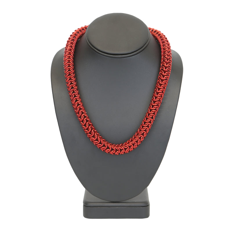 Intricately linked chunky chainmail necklace in crimson red on display stand