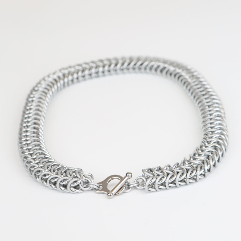 Intricately linked chunky silver chainmail necklace - closeup of toggle clasp