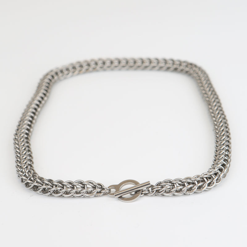Intricately linked chunky silver chainmail necklace - closeup of toggle clasp