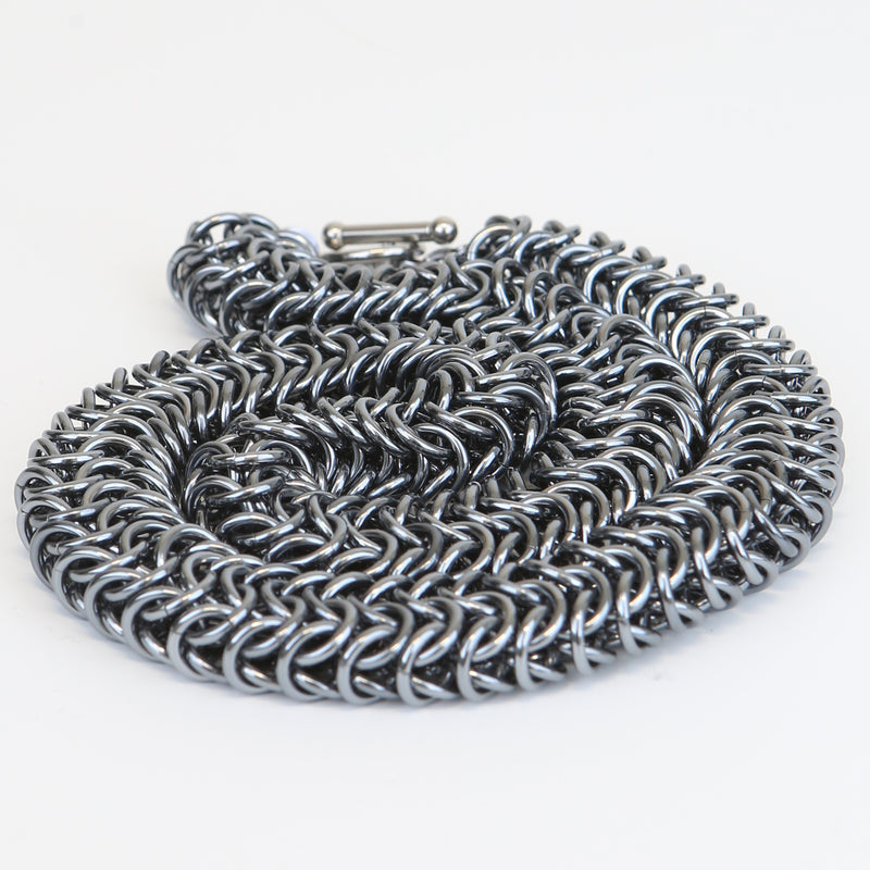 Intricately linked chunky gun metal silver necklace - displayed in neatly coiled pile