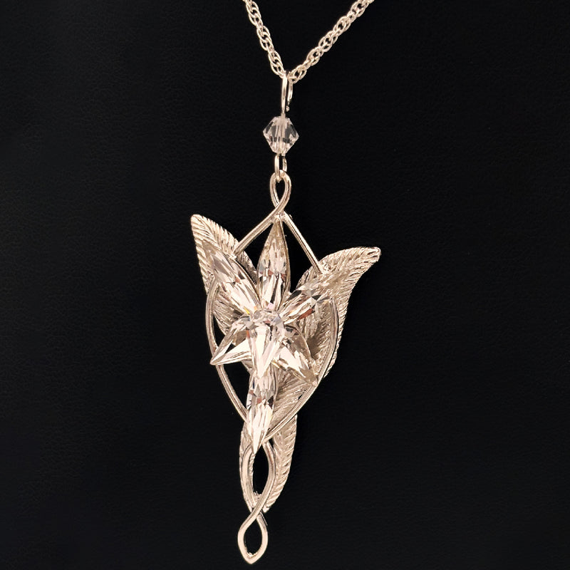 Silver leaf-shaped pendant on a chain against a black background