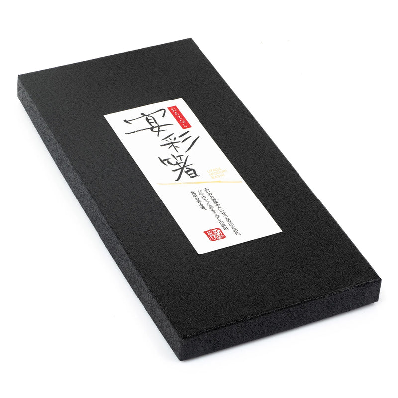 Black rectangular box with a white label featuring text and a red stamp on a white background