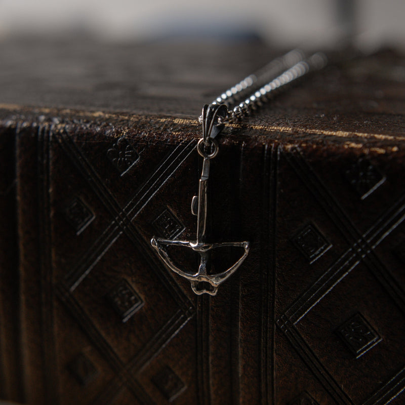 crossbow charm hanging off book