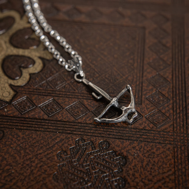 crossbow charm on book