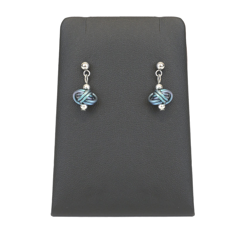 Silver stud earrings with looping ice blue chain details hanging from display stand
