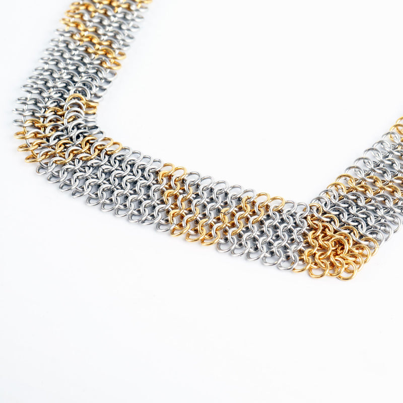 Necklace with interwoven silver and gold chainmail on a white background