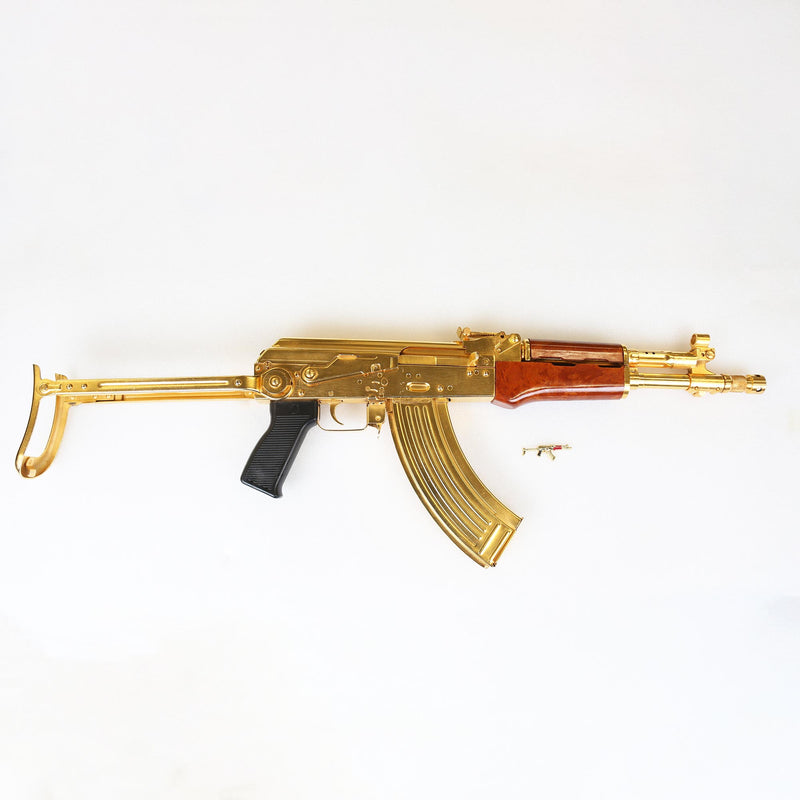 Golden Kalashnikov AK-47 Pin Badge next to the original from the Royal Armouries Collection