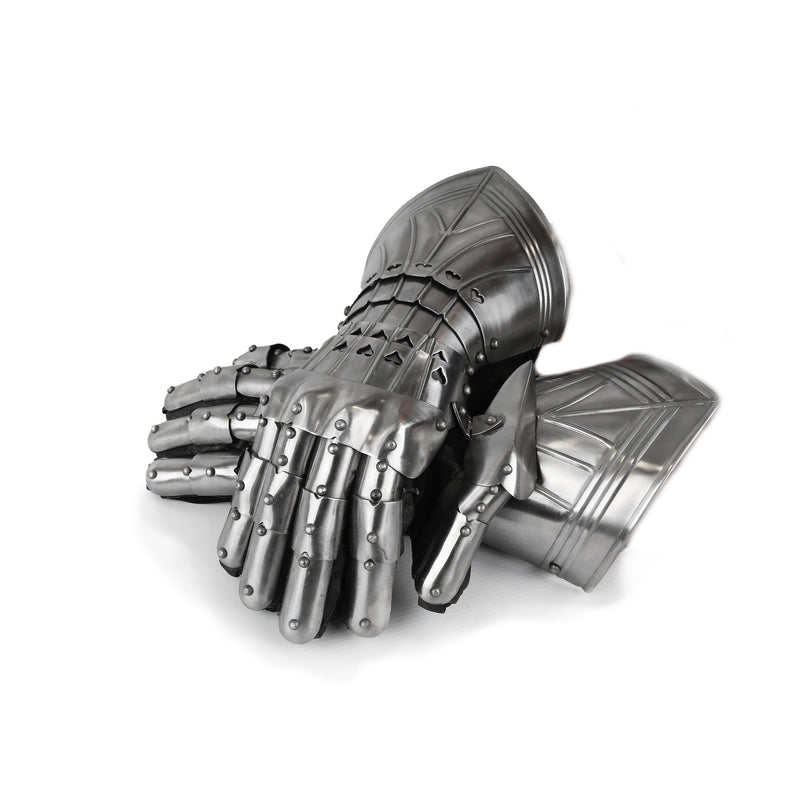 Pair of metallic gauntlets crossed over one another on a white background 