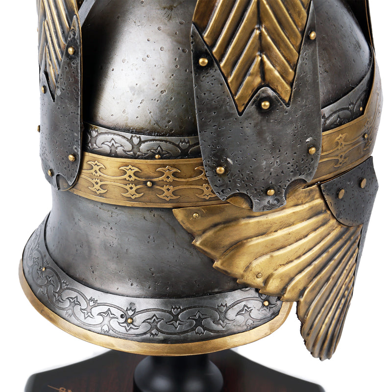 Close-up of a detailed metal helmet with gold accents on a white background