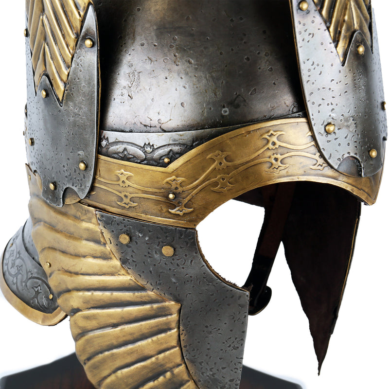 Close-up of a detailed metal helmet with gold accents on a white background