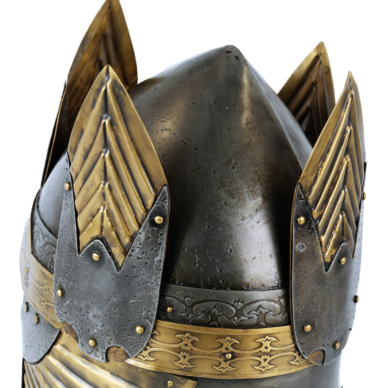 Close-up of a detailed helmet with gold and silver accents on a white background