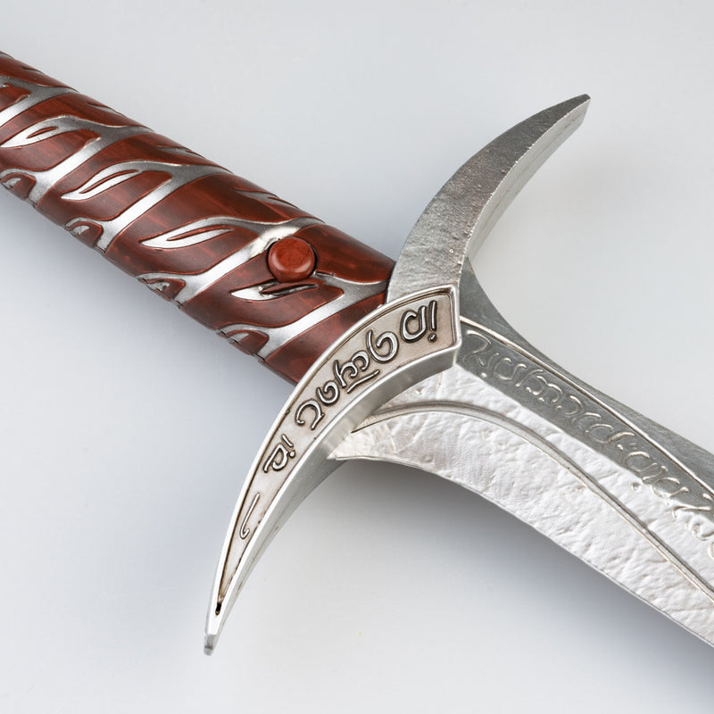 Decorative knife with a brown handle and silver blade on a light gray background