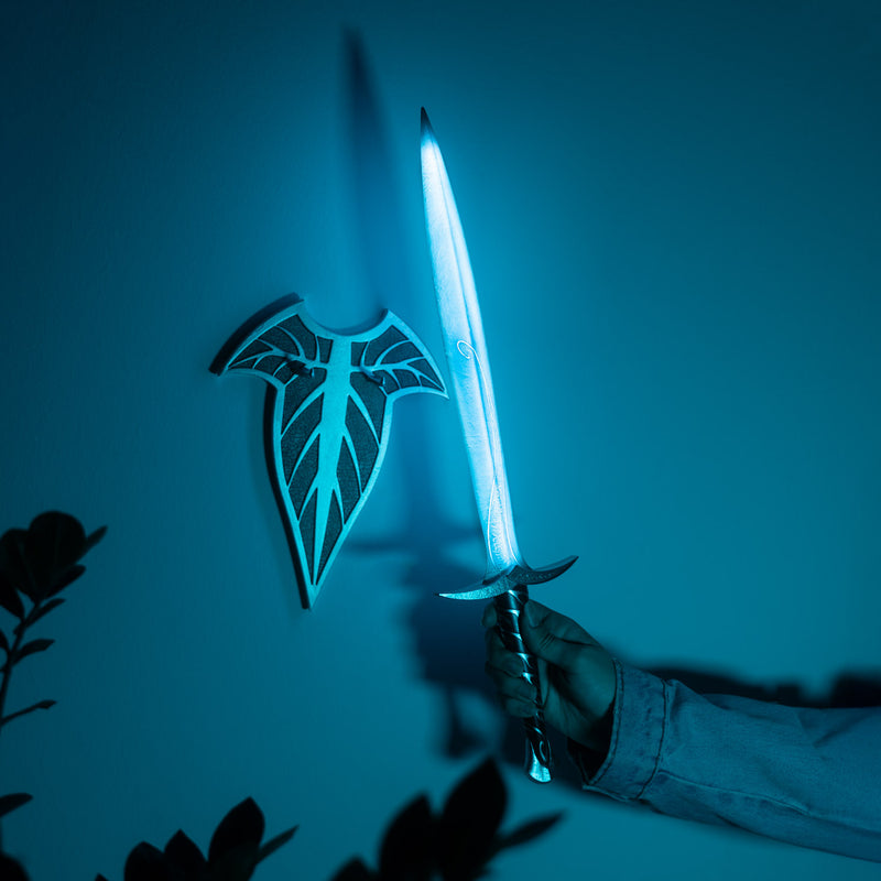 Glowing sword held by a person against a dark background