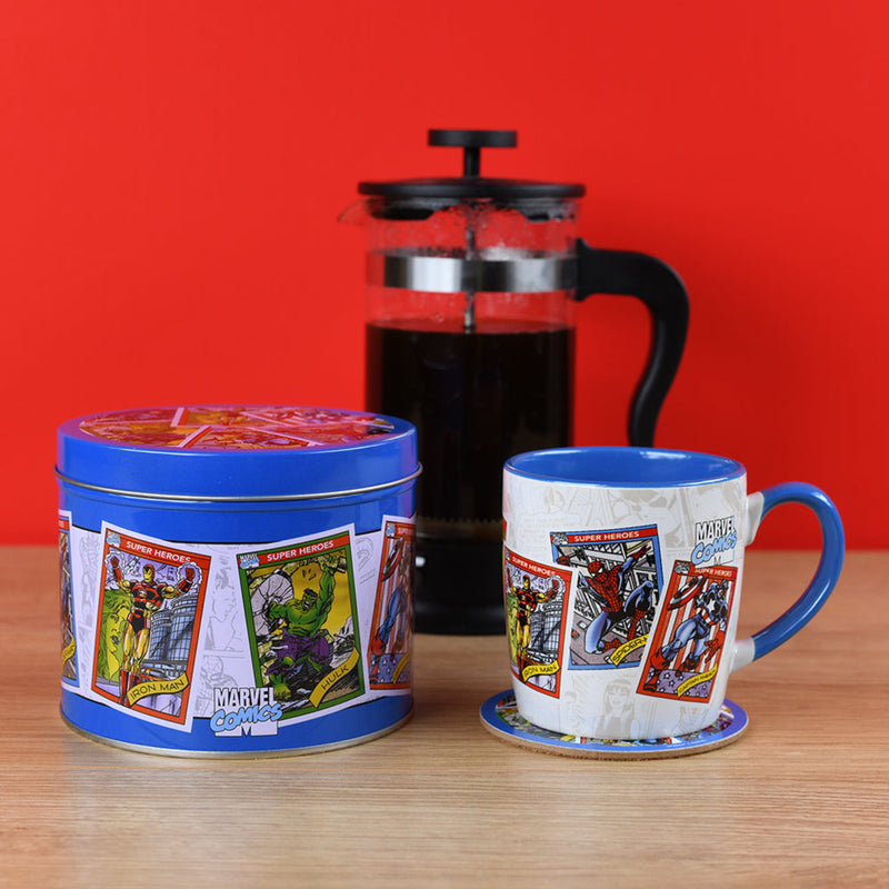 marvel comics mug and tin in front of a coffee press with a red background
