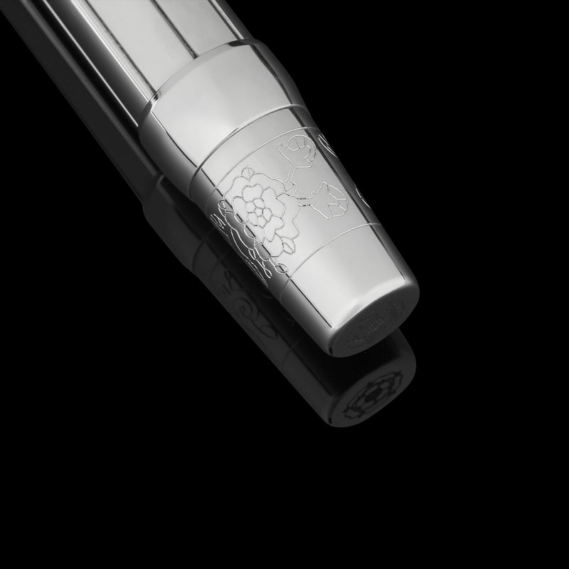 Silver pen with intricate design on a black background