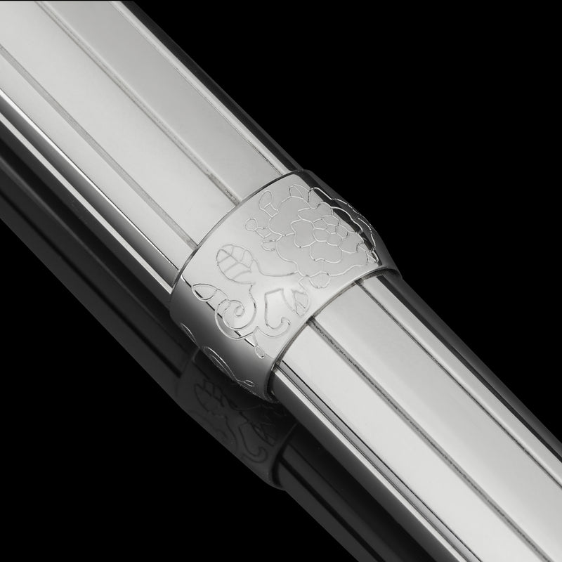 Close-up of a silver pen grip with intricate designs on a black background