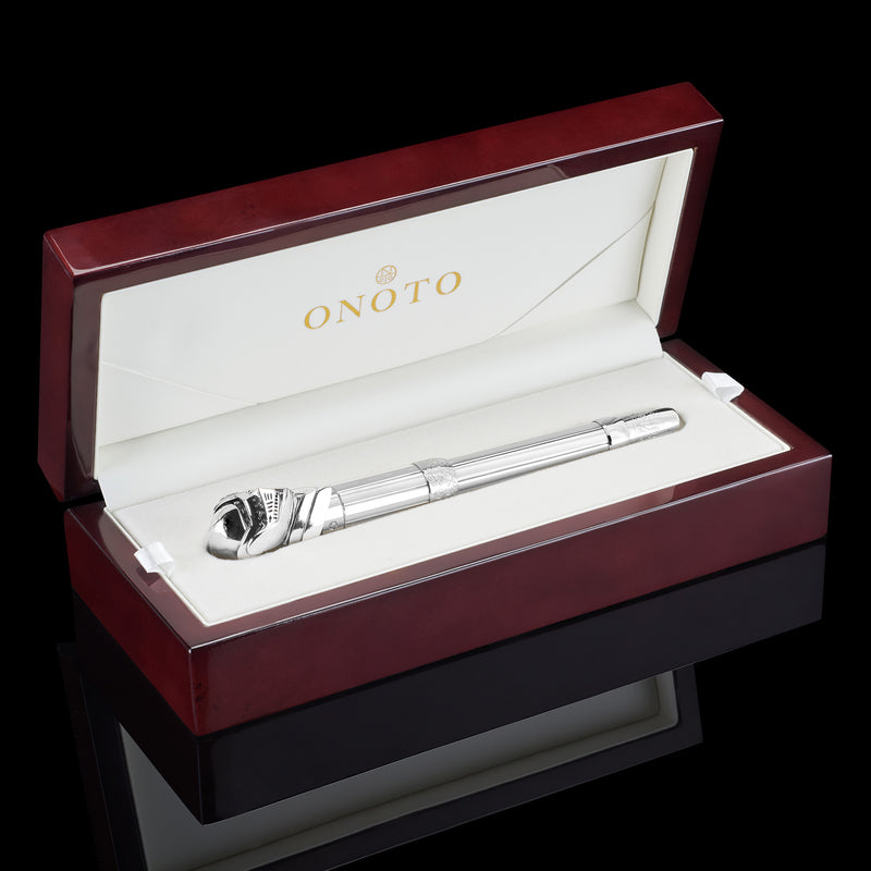 pen lying in reddish wood box on black background