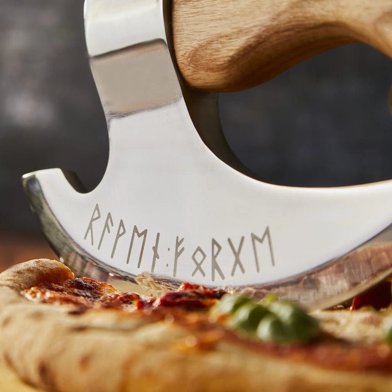 close up of the engraving on the pizza cutter while it's cutting into a pizza