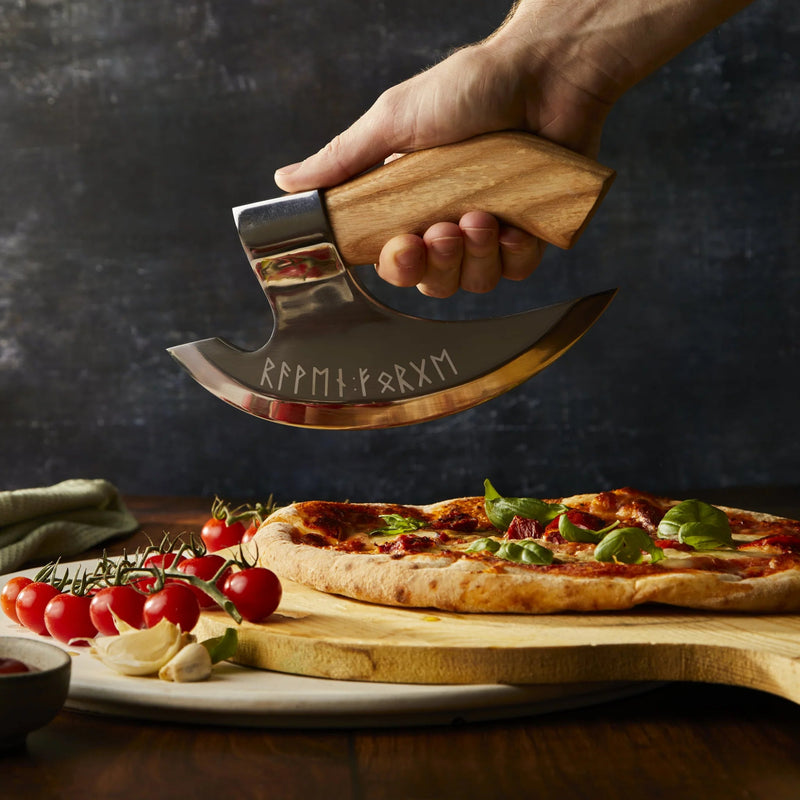 close up of the engraving on the pizza cutter while it's cutting into a pizza