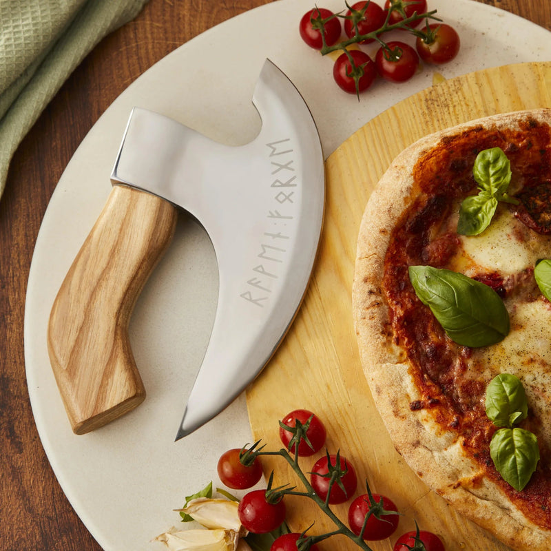 close up of the engraving on the pizza cutterlying next to a pizza