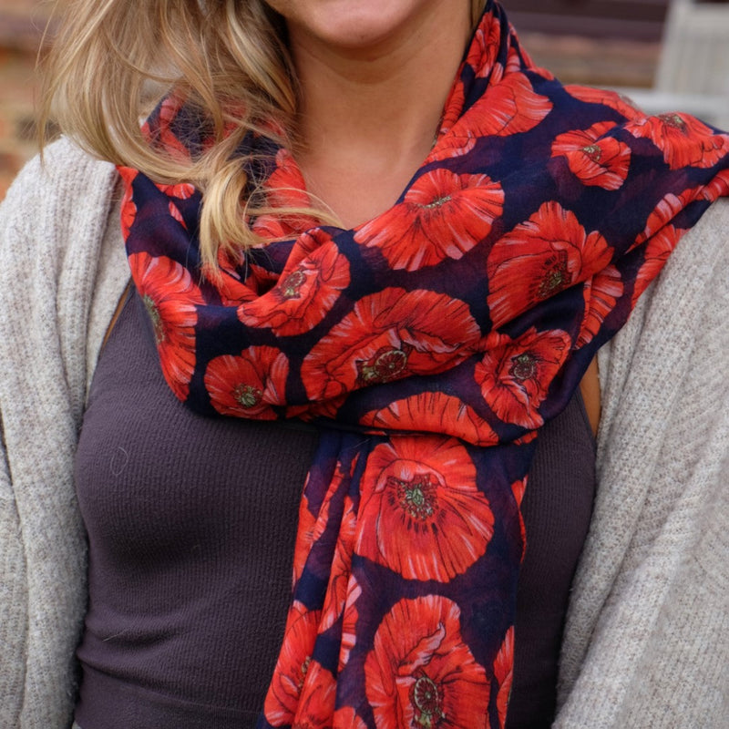 Person wearing a red floral scarf with a dark background