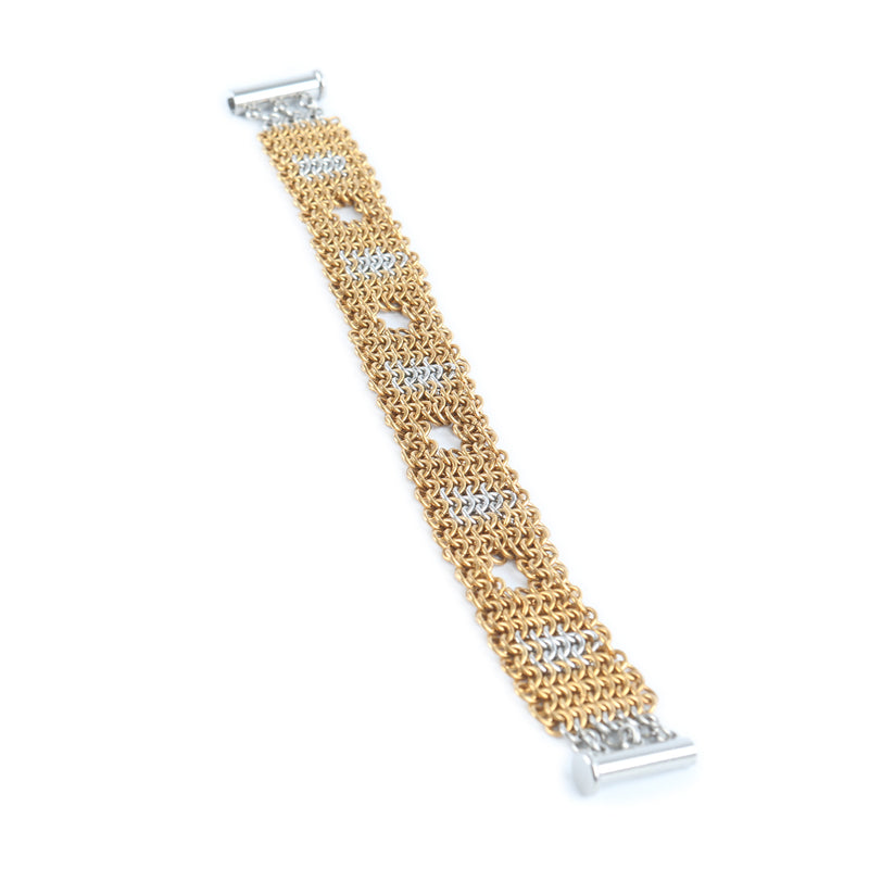 Gold and silver chainmaille bracelet stretched out on a white background