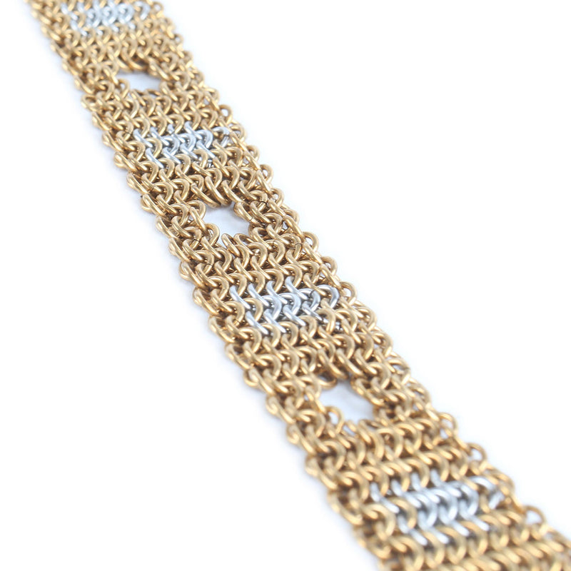 Gold and silver chainmaille bracelet on a white background