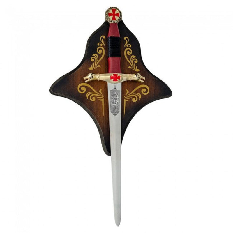 Decorative dagger featuring a red cross design displayed on a wooden plaque on a white background