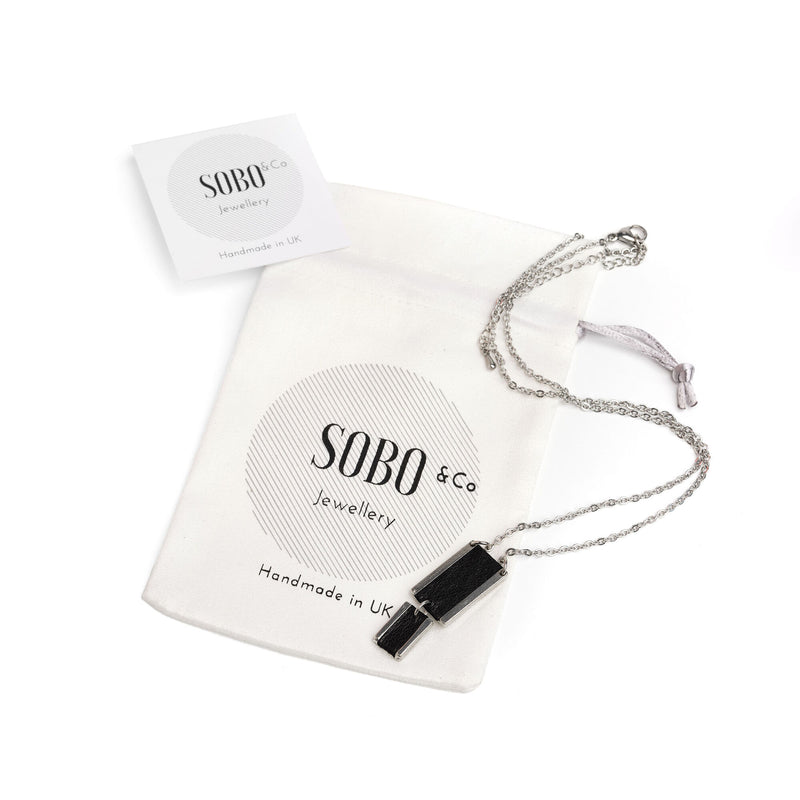 double rectange feature necklace with a black leather inlay with packaging pouch and card