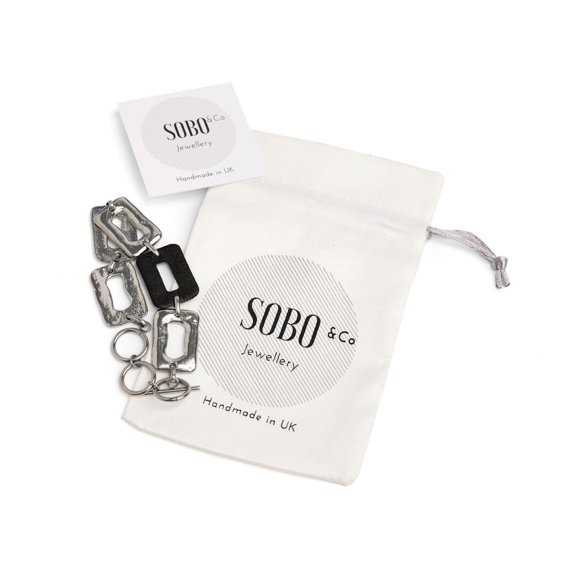 ring feature linked bracelet with black leather with packaging bag and card