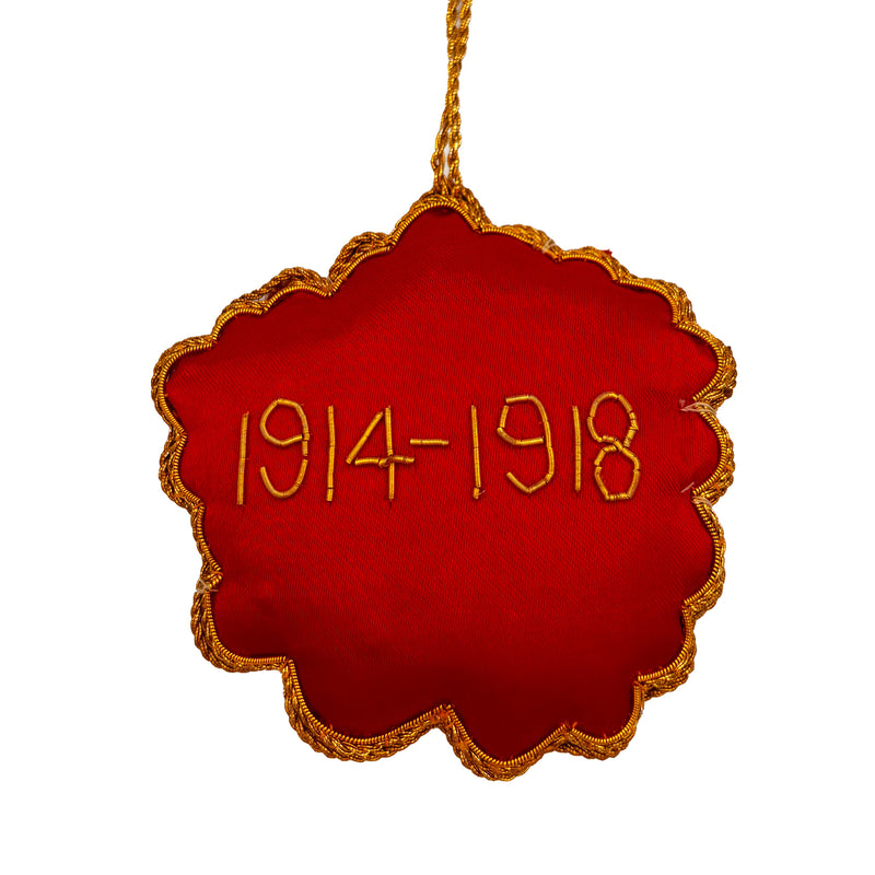 Red poppy flower ornament with gold beaded text reading 1914-1918 on white background